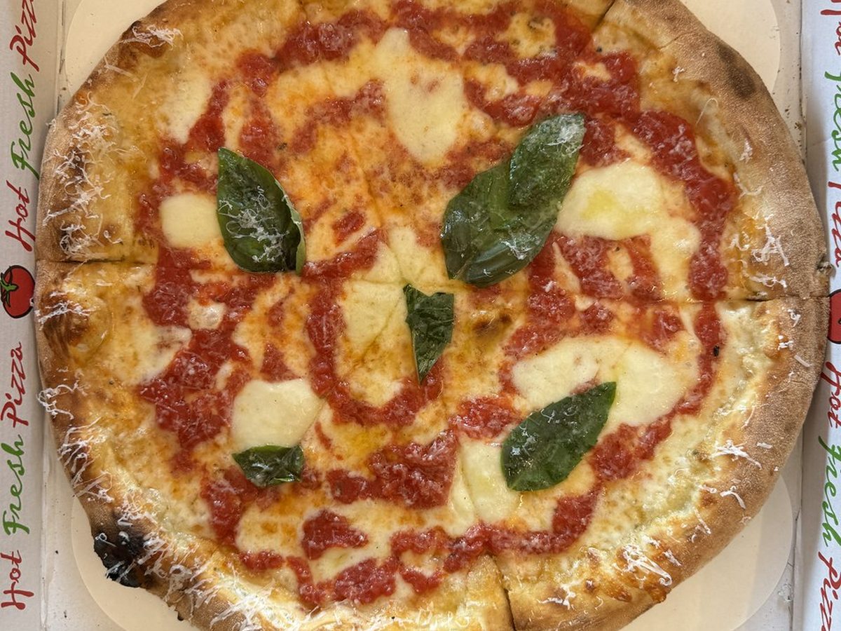 Pizza appena sfornata dentro al cartone da asporto