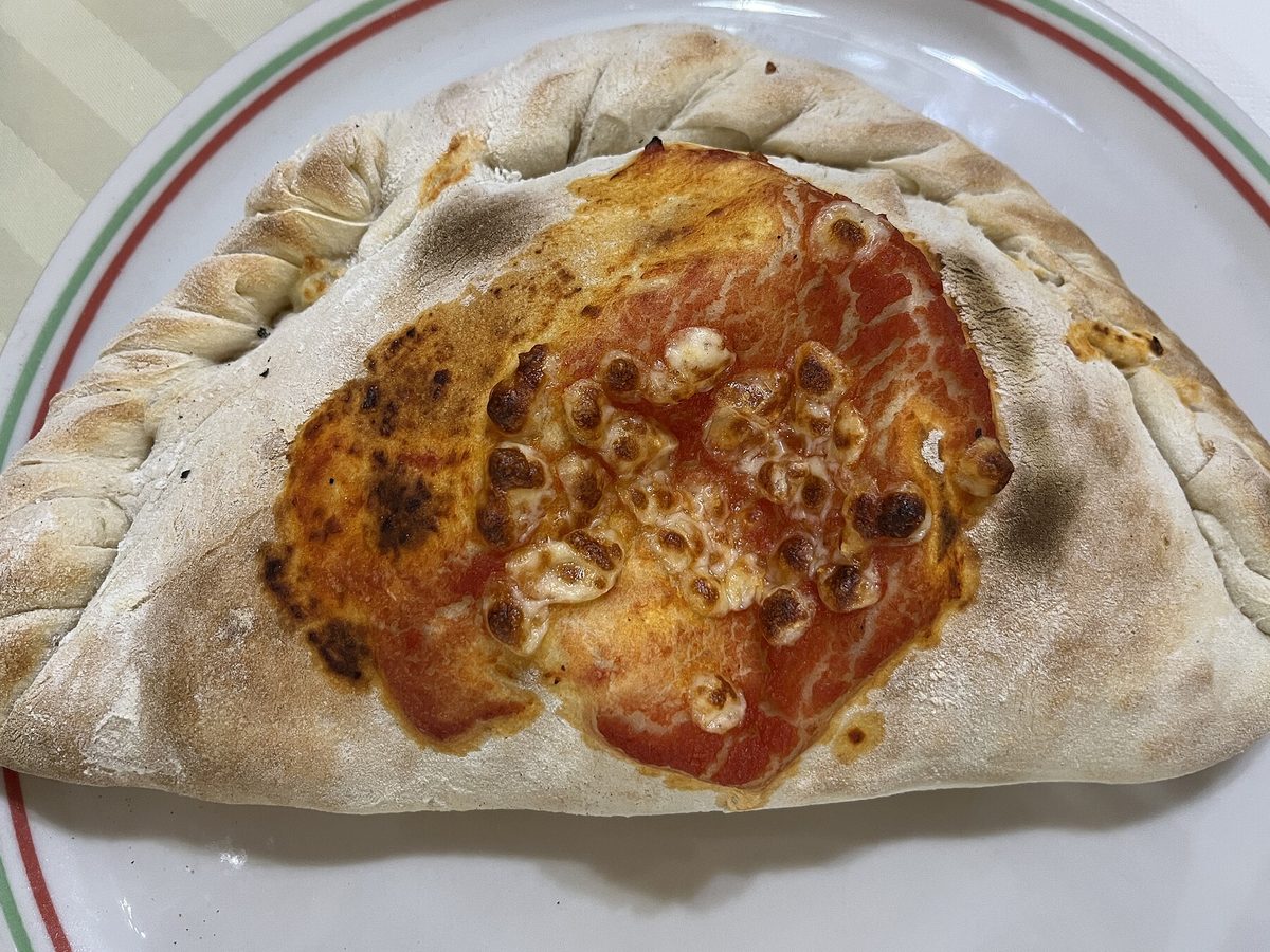 Calzone dorato appena uscito dal forno servito nel piatto